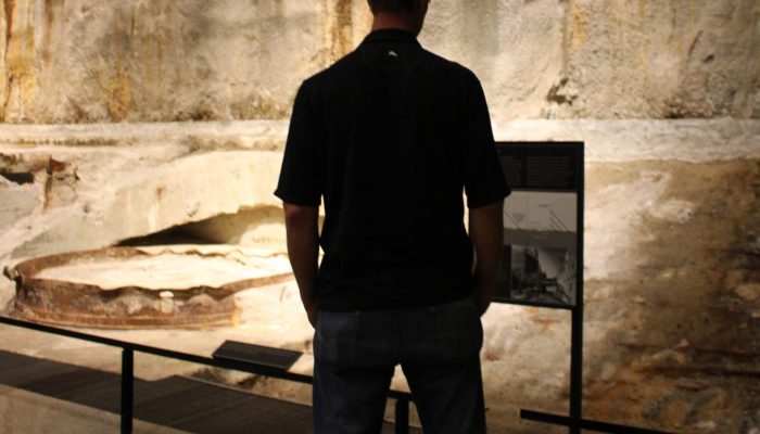 Silhouette of man looking at a museum artifact.